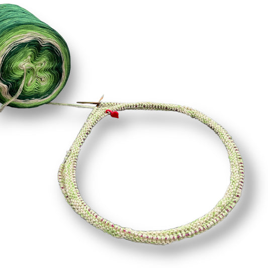 Rundstrickprobe in hellem Grün mit dezenten rosa Sprenkeln, gearbeitet mit handgefärbter Modal Farbverlaufswolle aus natürlichen Fasern – Möbius Anschlag Strickanleitung, Modal Farbverlaufsgarn zum Verlieben.