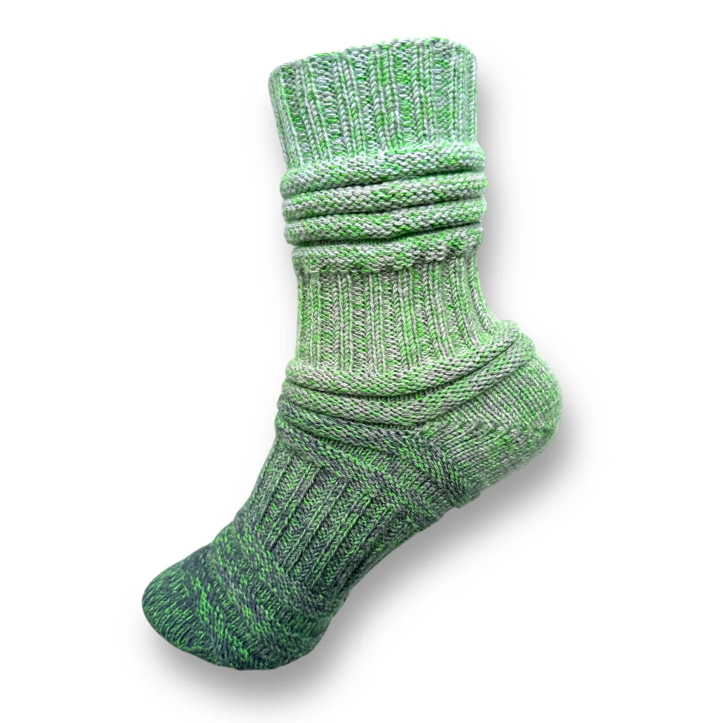 Farbvariante FRÜHJAHRSMÜDIGKEIT zeigt eine gestrickte Socke in verschiedenen Grüntönen, gefertigt aus Modal Farbverlaufsgarn mit natürlichen Fasern, Modal Farbverlaufsgarn zum Verlieben.