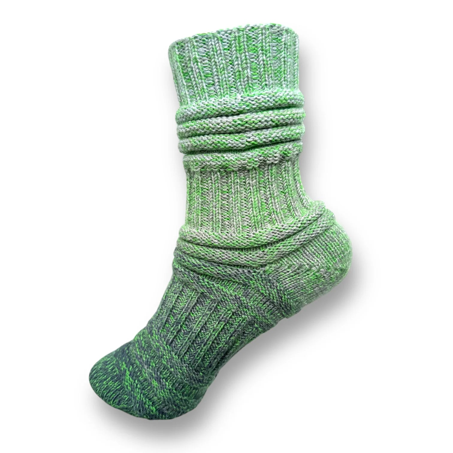 Farbvariante FRÜHJAHRSMÜDIGKEIT zeigt eine gestrickte Socke in verschiedenen Grüntönen, gefertigt aus Modal Farbverlaufsgarn mit natürlichen Fasern, Modal Farbverlaufsgarn zum Verlieben.