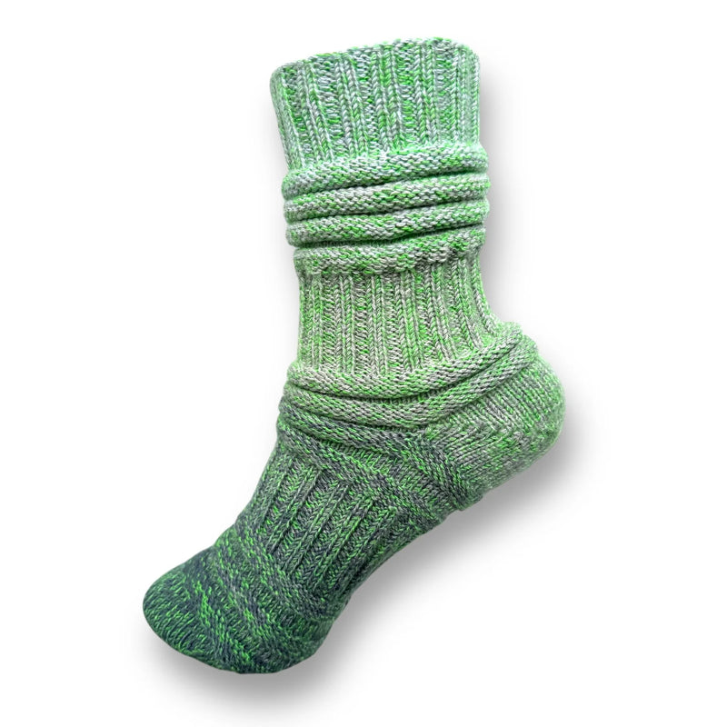 Farbvariante FRÜHJAHRSMÜDIGKEIT zeigt eine gestrickte Socke in verschiedenen Grüntönen, gefertigt aus Modal Farbverlaufsgarn mit natürlichen Fasern, Modal Farbverlaufsgarn zum Verlieben.