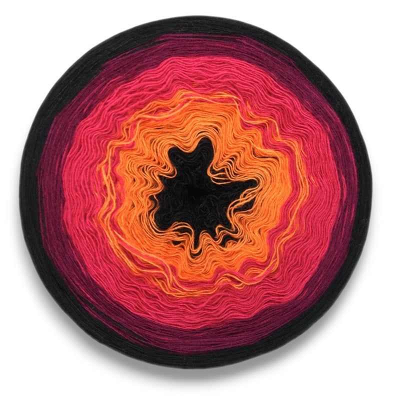 Farbvariante FETTE FETE mit lebendigem Farbverlauf von intensivem Schwarz über leuchtendes Orange zu kräftigem Pink und dunklem Magenta, handgefärbte Modal Farbverlaufswolle aus natürlichen Fasern – Modal Farbverlaufsgarn zum Verlieben.