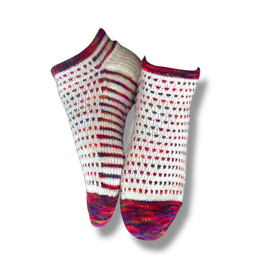 Gestrickte Socken in weiß mit bunten Farbverlaufsspitzen und Bündchen, gestaltet mit Sneaker Hopsasa Strickanleitung. Modal Farbverlaufsgarn zum Verlieben, natürliche Fasern, handgefärbte Wolle.