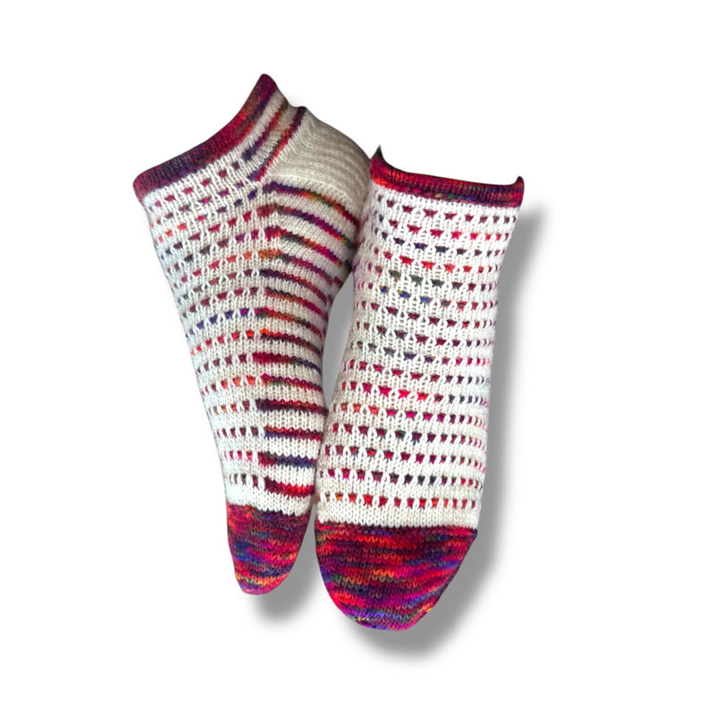 Gestrickte Socken in weiß mit bunten Farbverlaufsspitzen und Bündchen, gestaltet mit Sneaker Hopsasa Strickanleitung. Modal Farbverlaufsgarn zum Verlieben, natürliche Fasern, handgefärbte Wolle.