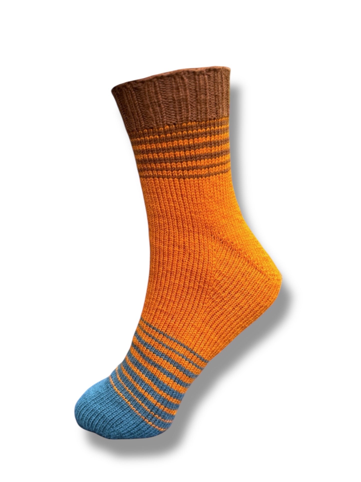 Sneaker & Socken Fade mit Monkferse Strickanleitung (Toe up) in lebendigem Orange mit Akzenten in Braun und Blau, gestrickt aus Modal Farbverlaufsgarn aus natürlichen Fasern – Modal Farbverlaufsgarn zum Verlieben.
