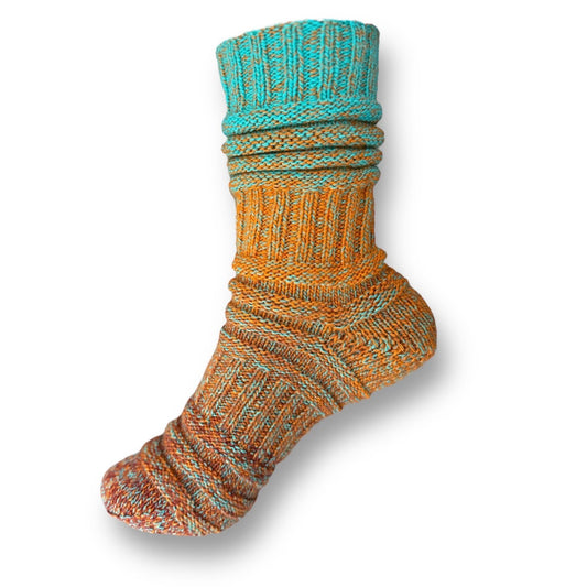 Sockenvariante SCHNABELSCHUH mit lebendigem Farbspiel von warmem Orange bis frischem Türkis, kombiniert mit abwechslungsreichen Mustern aus handgefärbter Modal Farbverlaufswolle natürlichen Ursprungs – Modal Farbverlaufsgarn zum Verlieben.