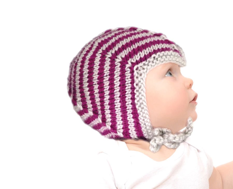 Babymütze Teufelchen Strickanleitung zeigt eine süße, handgestrickte Baby-Mütze mit kontrastierendem Streifenmuster in Pink und Grau, gefertigt aus Modal Farbverlaufsgarn natürlichen Fasern – Modal Farbverlaufsgarn zum Verlieben.
