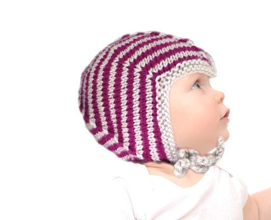 Babymütze Teufelchen Strickanleitung zeigt eine süße, handgestrickte Baby-Mütze mit kontrastierendem Streifenmuster in Pink und Grau, gefertigt aus Modal Farbverlaufsgarn natürlichen Fasern – Modal Farbverlaufsgarn zum Verlieben.