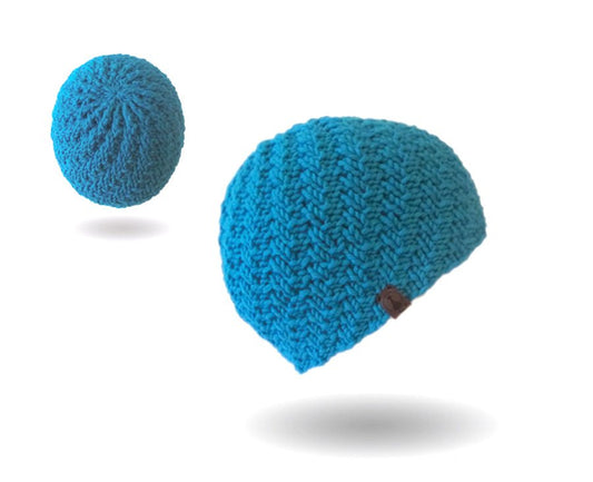 Mütze mit versetzten Rippen Strickanleitung zeigt eine leuchtend blaue, handgestrickte Mütze mit strukturierter Rippenoptik, gefertigt aus Modal Farbverlaufsgarn natürlichen Fasern – Modal Farbverlaufsgarn zum Verlieben.